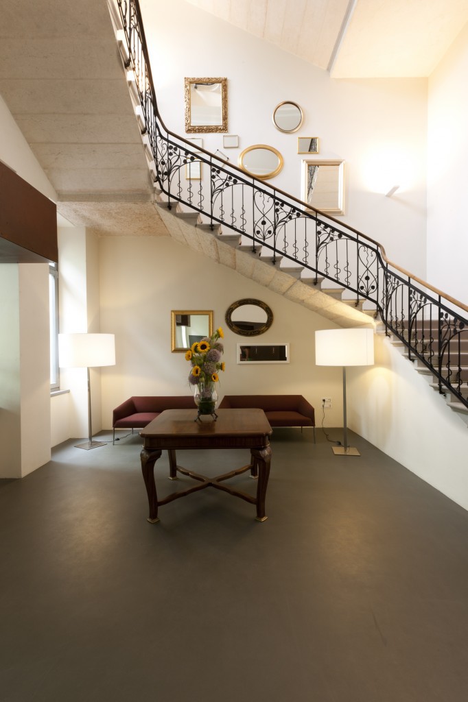 Das Treppenhaus mit dem schmiedeeisernen Geländer wird durch moderne italienische Designer-Möbel kontrastiert.